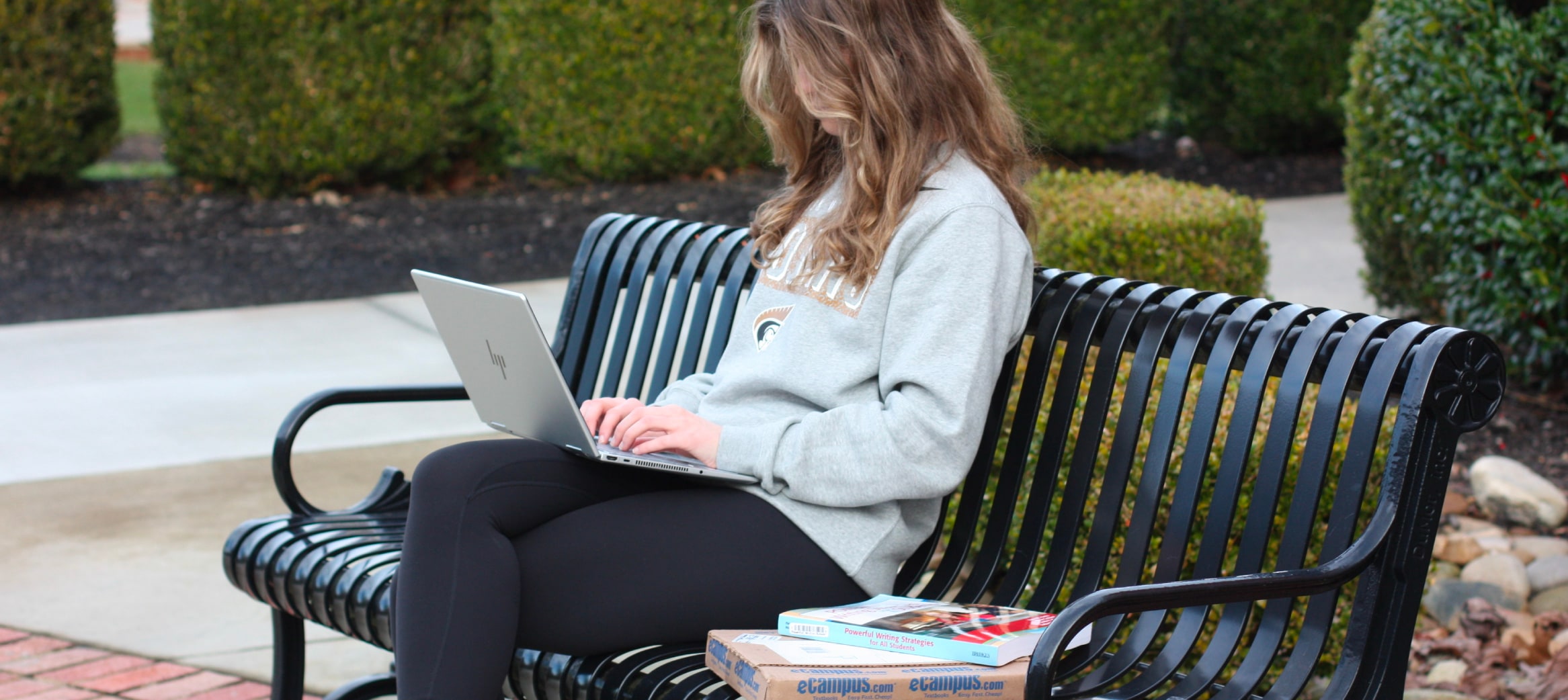 Image of student with laptop and textbooks